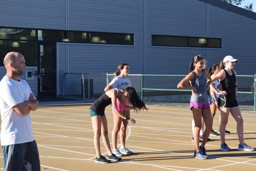 Sac State cross country coach David Monk and a few members of the women's team watch as their fellow teammates run during practice on Wednesday, Sept. 26.