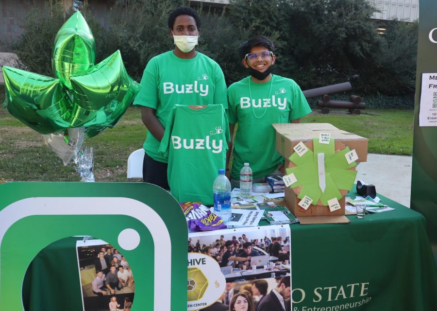 App co-creators Srinjay Verma (right), a computer engineering major, and Abubeker Hussen (left), a mechanical engineering major, pose in front of the Buzly app table in the quad during the Club Days event Monday, Feb. 7. The two engineering majors built the app with the intention to encourage a more involved campus community. 
