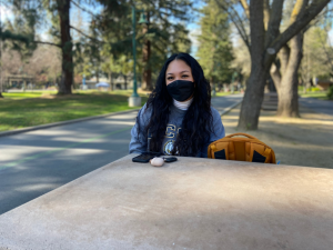 Therese Gatchalian, a third-year pre-nursing major, sits near the library benches on Friday, Feb 18. Gatchalian said she agrees with the campus's continued requirement to wear masks indoors and feels that masks protect students when social distancing in classrooms is impossible. (Photo by Priscilla Garcia-Pargas)


